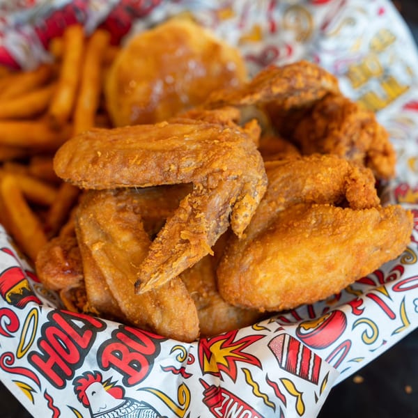 Holy Buckets Halal Chicken & Chicken fried chicken wings and fries in a branded paper-lined basket.